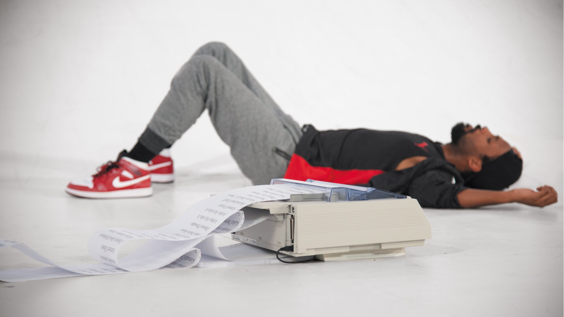 One young boy in a striped shirt holding a bright green toy gun and three other young men in the background