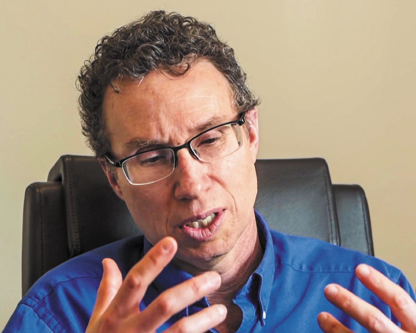 Headshot of Dr. Andrew Newberg wearing glasses and a blue dress shirt