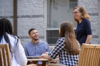 Graduate liberal studies students talking with a professor in a campus courtyard Graduate liberal studies students talking with a professor in a campus courtyard