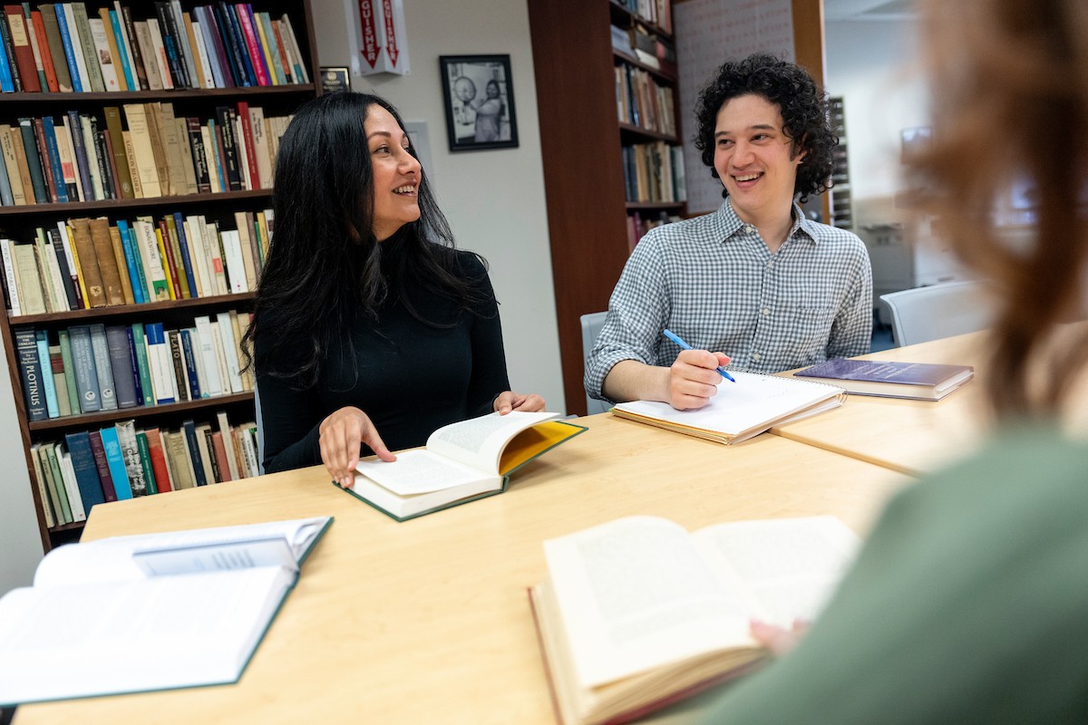A graduate student and a faculty member interact in a classroom.