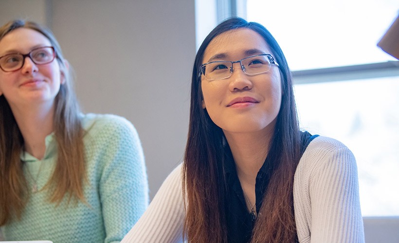 Two female students listen intently to a lecture. Two female students listen intently to a lecture.