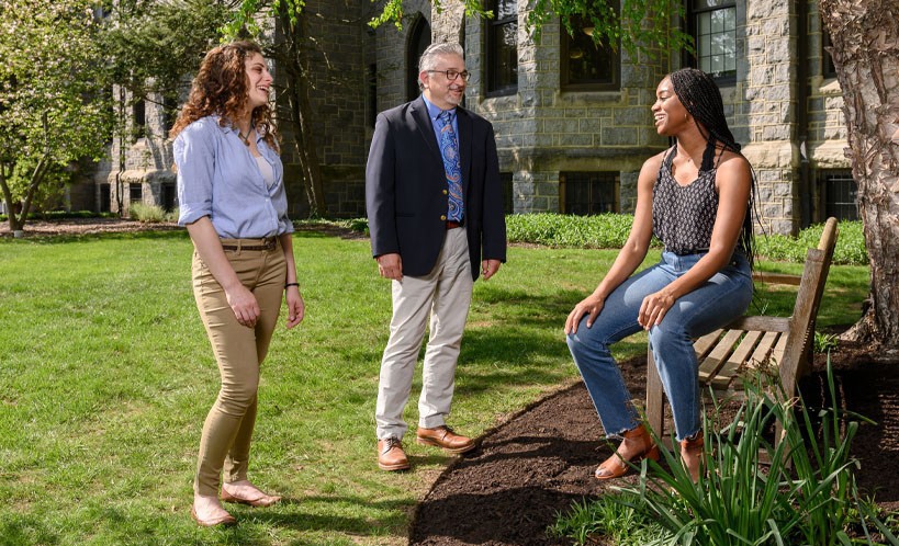 Students and a faculty member talking outside of a building.
