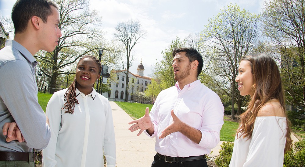Doctoral students talking in a small group in the spring students talking in small group
