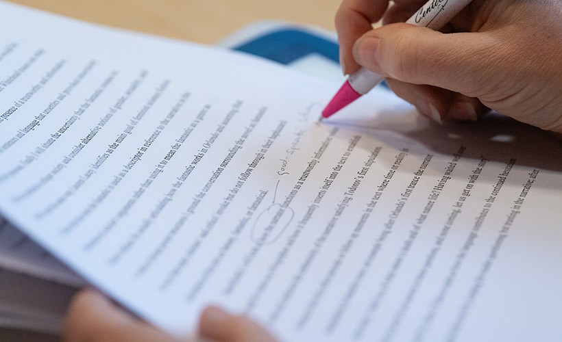 A close up of a student reviewing a paper. A close up of a student reviewing a paper.