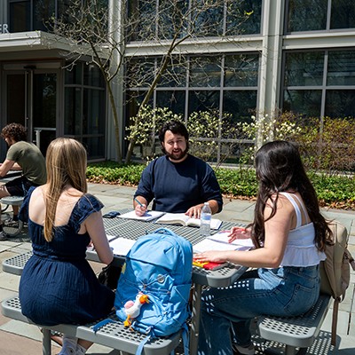 students sitting outside at a table