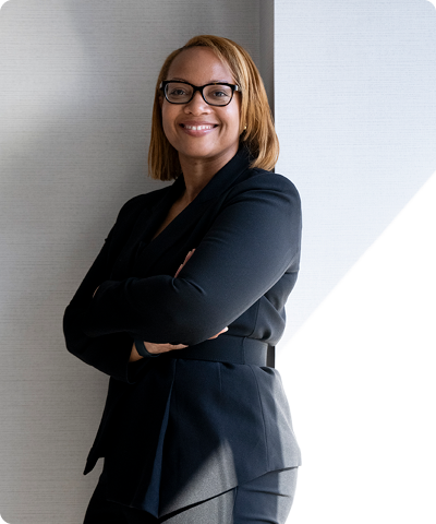 woman in glasses standing and smiling at the camera