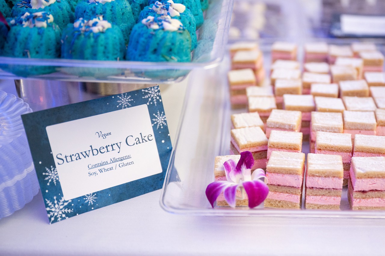 Strawberry cake with a sign detailing allergens.
